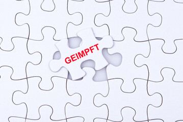Fototapeta premium Ein Puzzle mit einem Puzzleteil auf dem GEIMPFT steht