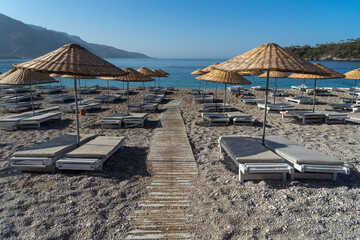 Umbrellas beach and sun loungers on the beach in Turkey, no people early morning