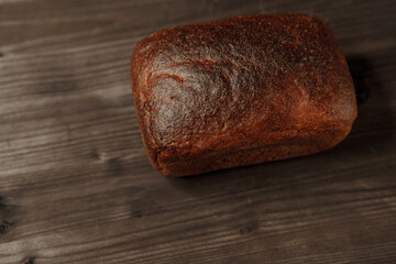 freshly baked black rye bread on a dark background.