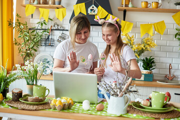 Mom and daughter on Easter holiday congratulate their relatives through a laptop