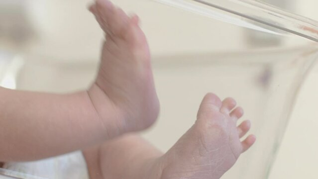 Baby feet closeup. Tiny Newborn Baby's leg. Child on table. Happy Family concept. Beautiful conceptual video of Maternity.