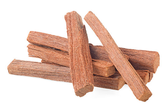 Chandan. Brown sandalwood isolated on a white background. Pile of sandalwood sticks. 