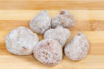 Dried figs on the bamboo wooden surface, close-up