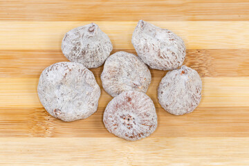 Dried figs on the wooden surface, top view close-up