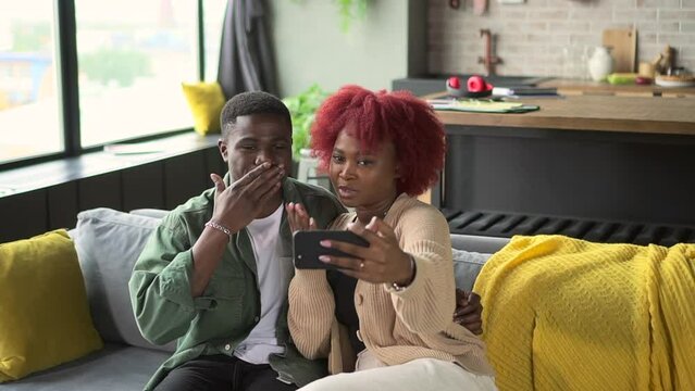 African couple wave hand at video call on phone Spbd. Black man and woman communicate with family and finish virtual online conversation. Loving boyfriend and girlfriend talk to relatives