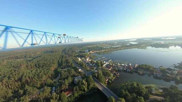 FPV drone view quickly flies near a construction crane and an unfinished apartment building at dawn