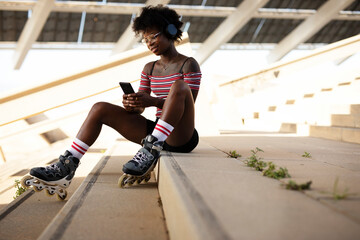 Beautiful African woman with roller skates. Urban sexy girl enjoy outdoors.