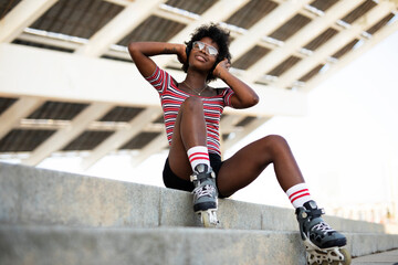 Beautiful African woman with roller skates. Urban sexy girl enjoy outdoors.