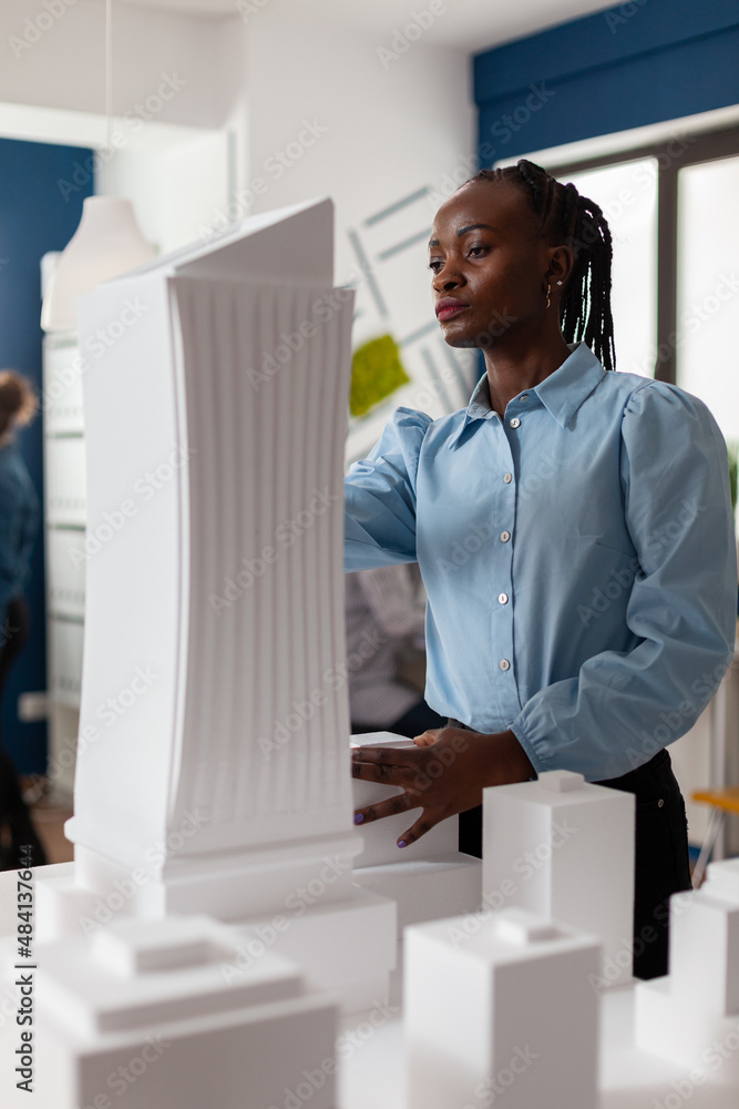 Poster portrait of architect looking at the architecture design of futuristic building at desk with residen