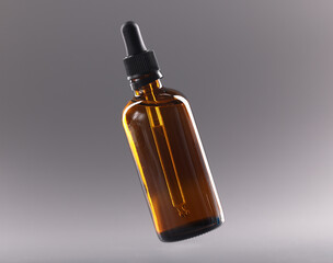 Fototapeta premium Glass bottle with cosmetic oil on gray background closeup