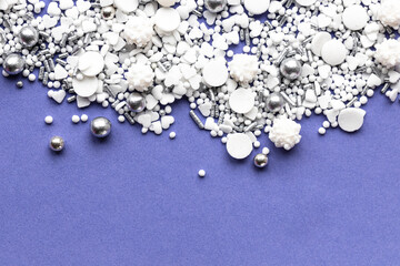weiße und silberne Zuckerstreusel auf lila Hintergrund