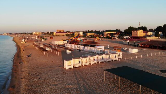 Drone shot of Zatoka resort. Drone view of people sunbathing on the beach near the sea in Odessa. Wide sandy beaches near the Black Sea. People swim in the sea. 