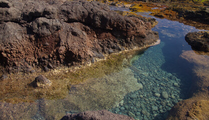 Gran Canaria, calm rock pools under steep cliffs of the north coast are 
separated from the ocean by volcanic rocks of platform constructed by old lava flows
Punta de Galdar area
