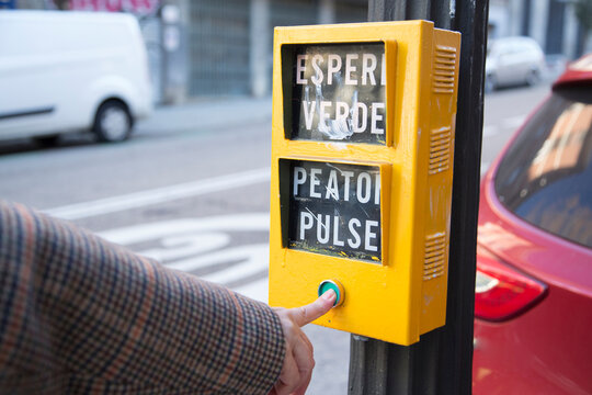senior Caucasian woman's hand pressing the yellow traffic light button with green button