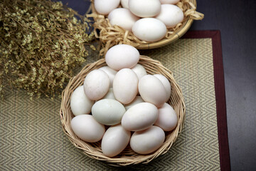 Close-up white eggs in wicker basket