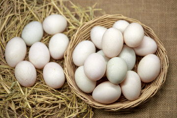 Close-up white eggs in a wicker basket