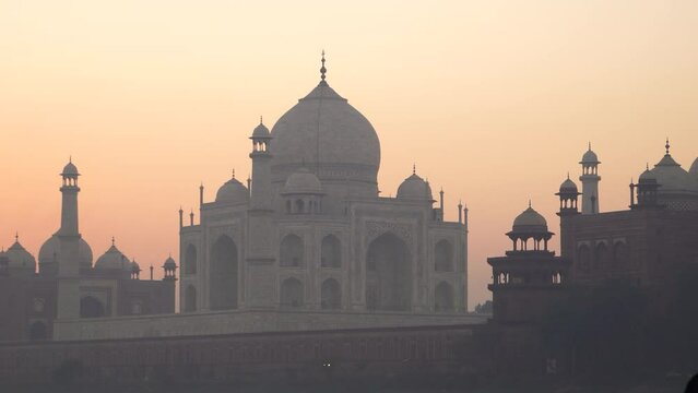 A telephoto shot of Taj mahal in the morning. Shot of Taj Mahal in the morning sunrise with orange sky, forming silhouette.