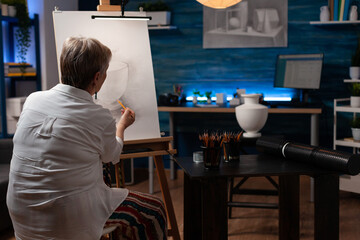 Older woman shading sketch in light study in evening class feeling inspired drawing still life vase...