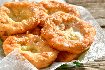 Traditional home made deep fried  patties  covered with sugar  оn rustic backgroud.Mekitsa or Mekica,  on wooden  rustic  background. Made of kneaded dough that is deep fried  .Carnival tortelli stuff