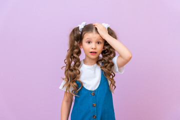 A frustrated girl holds her hand on her head, an offended child on an isolated background.