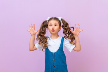 The little girl rejoices and jumps, child is in a good mood to have fun and makes grimaces.