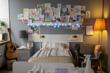 Image of bed of sick patient and drawed pictures on the wall in hospital ward