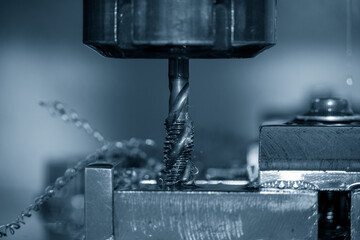 The closeup scene of machine tapping process on CNC machine.