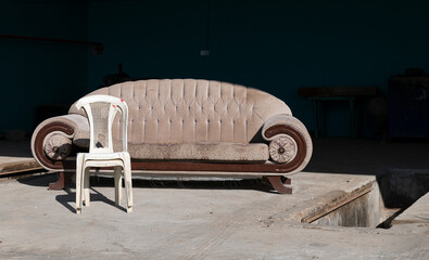 Social issue, environment concept - old sofa and chair lefted in the street. Abandoned places with old furniture. Old furniture left in the street. 