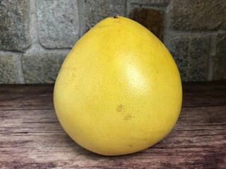 yellow pomelo on a wooden background