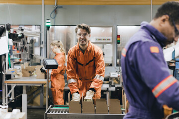 Portrait of smiling male expertise in protective workwear working in industry