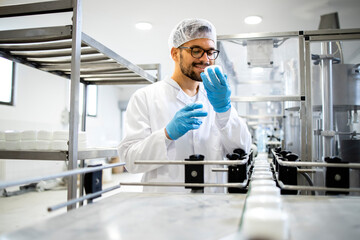 Technologist worker checking quality of natural cosmetics creme products.