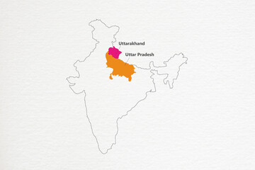 Uttar Pradesh and Uttarakhand state highlighted on Indian map on textured paper background.