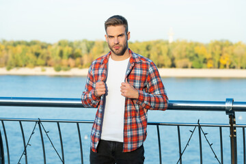young bearded guy in checkered shirt outdoor, lifestyle