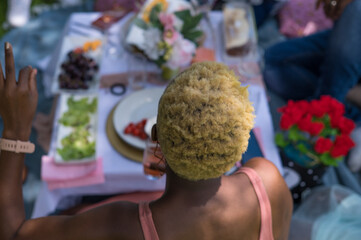Rear view of woman with colorful hair seated outdoors