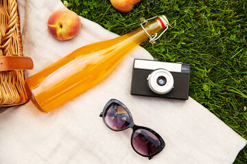 leisure and summer concept - close up of picnic basket, bottle of fruit juice with sunglasses and...