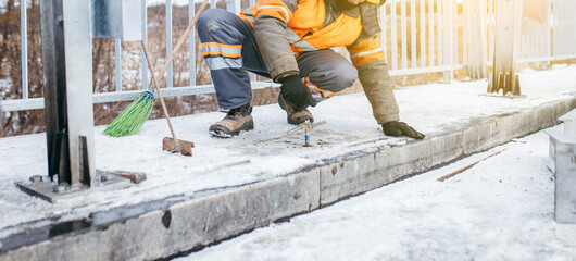 Road workers installing a new fence railing of bridge, outside the city 