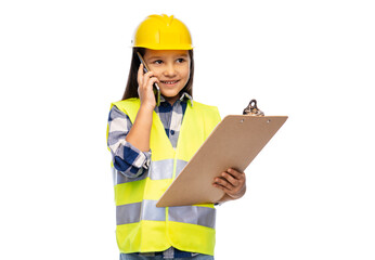 building, construction and profession concept - smiling little girl in protective helmet and safety vest with clipboard calling on smartphone over white background