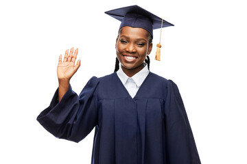 education, graduation and people concept - happy graduate student woman in mortarboard and bachelor gown waving hand over white background