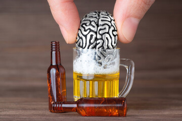 Drowning human brain model in a beer mug