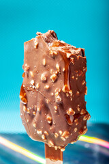 
Chocolate ice cream with almonds. On a stick. On a blue background