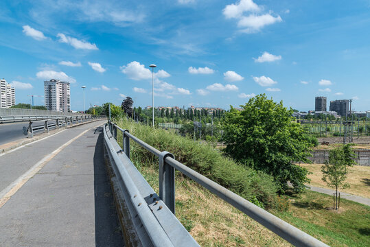 Road with guardrail. Skyline of the city of Quarto Oggiaro and via Palizzi which crosses the railway. Quarto Oggiaro is a district of Milan from which it is a few km, northern Italy