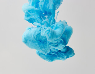 Blue ink drop in water over gray background