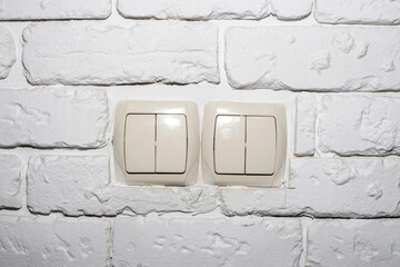 Electrical light switches on a gypsum brick wall.