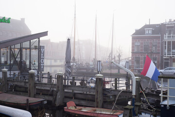 12 January 2022, Leiden, the Netherlands, A misty day, with an old boat on the front and mist...