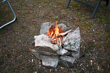 Lagerfeuer am Campingplatz im Urlaub in Schweden Norwegen Skandinavien mit Steinen und selbst...