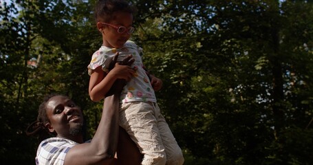 Dad and daughter play on the playground in the forest in summer. Parents and their involvement in...