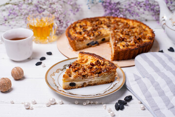 a piece of cut pie with nuts and raisins on a white background