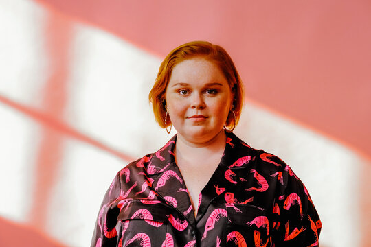 Smiling Young Milennial Woman Posing In Studio Over Pink Background