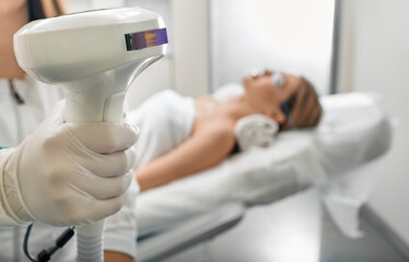 Beautician holding Lumecca device with intense pulsed light IPL technology for photorejuvenation of...