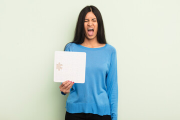 young pretty hispanic woman shouting aggressively, looking very angry. puzzle concept